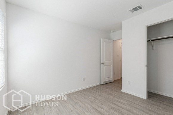 a bedroom with a white wall and a door to a closet