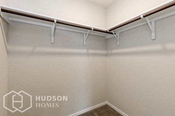 an empty closet with white walls and white hudson homes