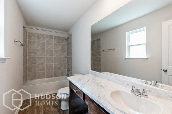 a bathroom with a sink and a shower and a toilet