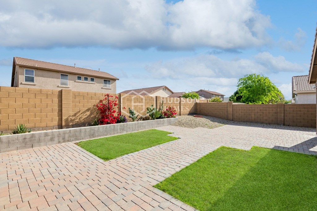 a backyard with a brick patio and grass