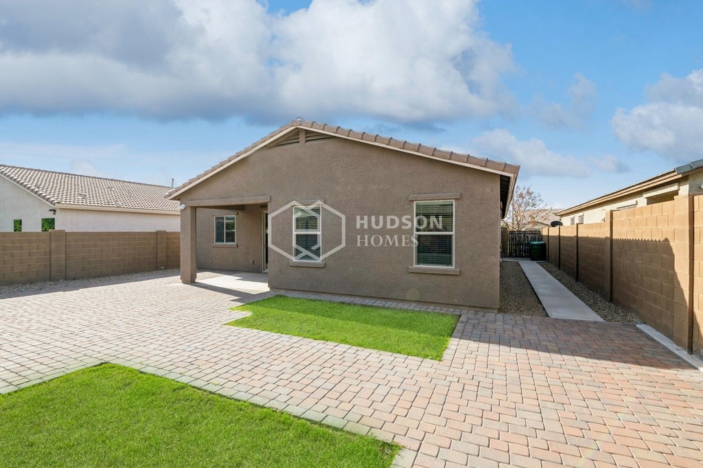 a brick house with a driveway and a lawn