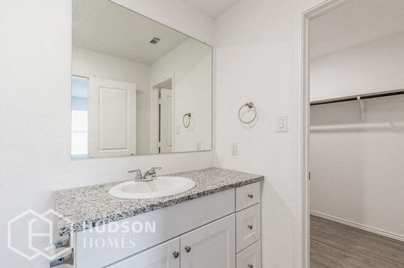 a white bathroom with a sink and a mirror