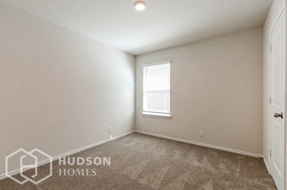 the living room of a home with a window and a carpeted floor