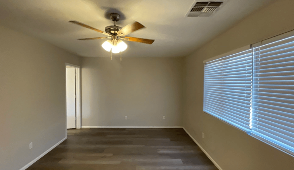 a living room with a ceiling fan and a large window
