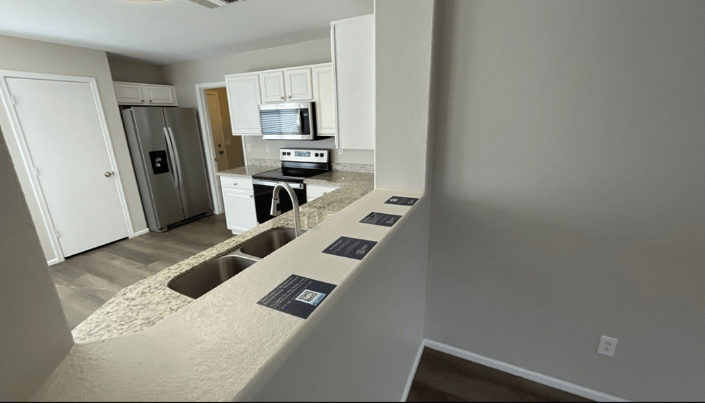 a kitchen with white cabinets and granite counter tops