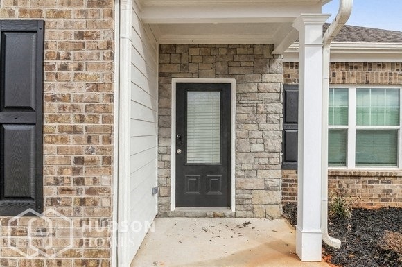 a front porch of a brick house with a black door
