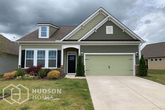 a house with a green garage door on a cloudy day