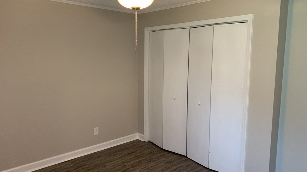 a bedroom with two white closet doors and a lamp