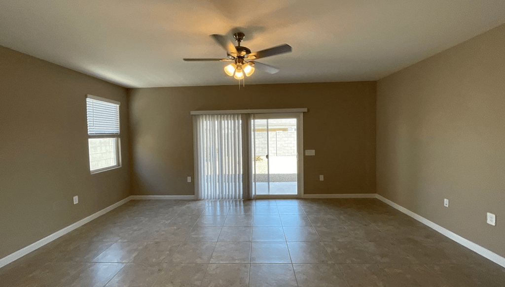 an empty living room with a ceiling fan