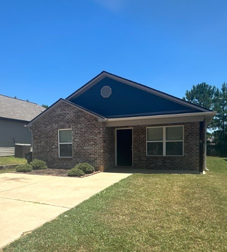 a brick house with a sidewalk in front of it