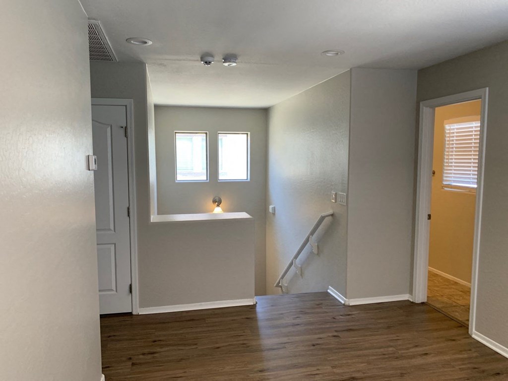 an empty room with a staircase and a window