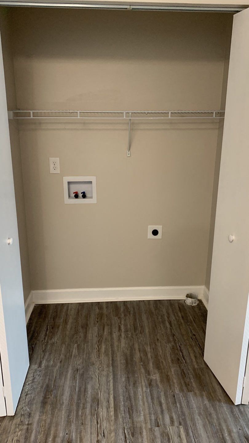 a large empty room with wood floors and a closet