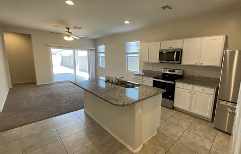 an empty kitchen with a granite counter top