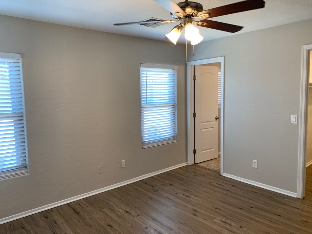 a living room with a ceiling fan and a door