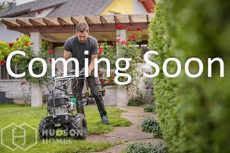 a man cutting a lawn with a lawn mower   coming soon
