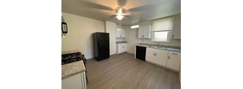 A kitchen with a black fridge and white cabinets.at North Pointe Commons Apts, Pittsburgh, 15229