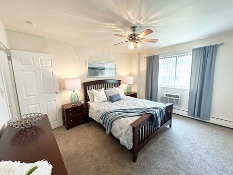 A bedroom with a large bed and a ceiling fan.