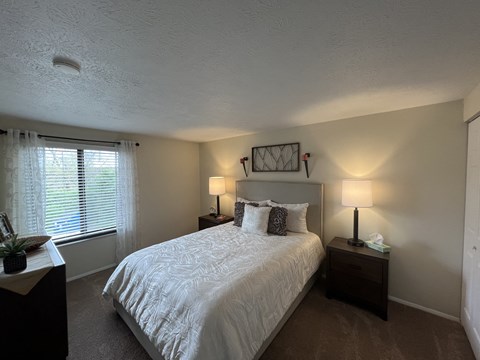 a bedroom with a large white bed and a window at Deauville Park Apartments, Monroeville, PA