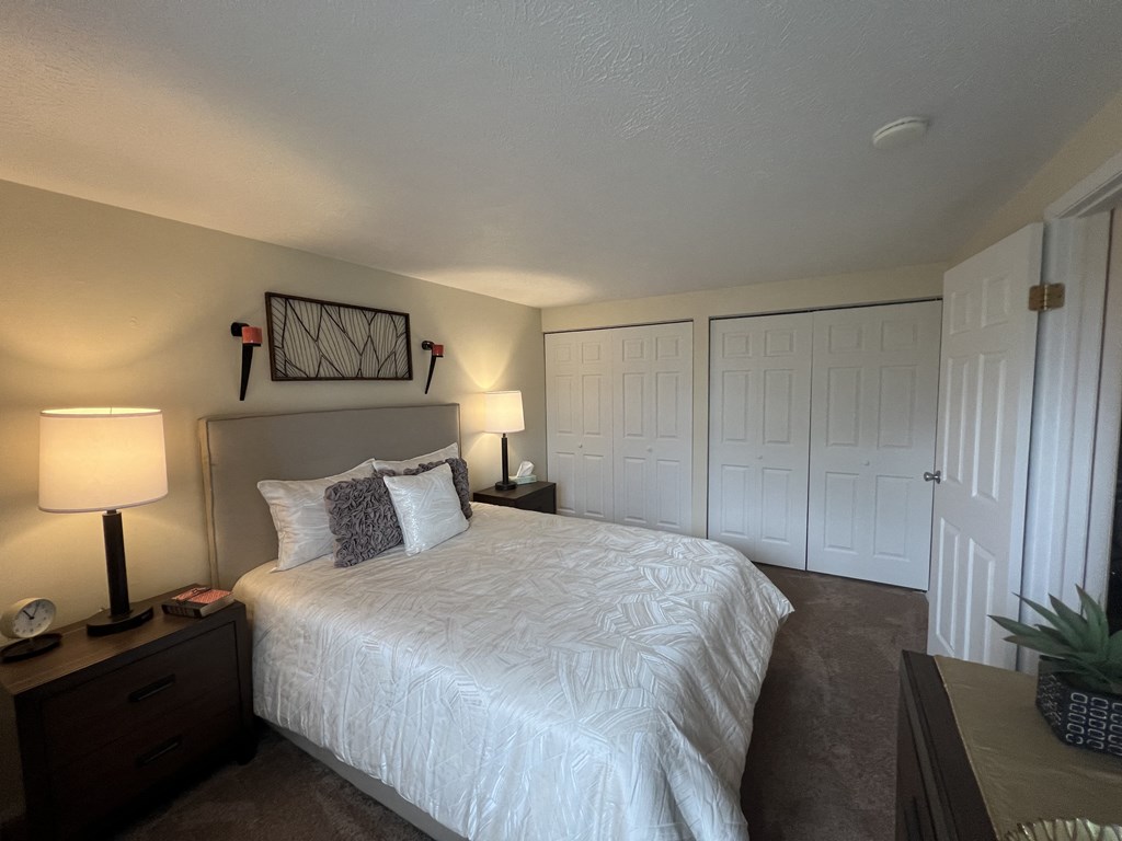 a bedroom with a large white bed and a closet a bedroom with a large white bed and a closet at Deauville Park Apartments, Monroeville, 15146