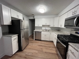 a kitchen with white cabinets and stainless steel appliances