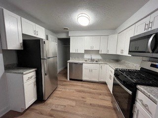 a kitchen with white cabinets and stainless steel appliances at Lavale Apartments, Monroeville