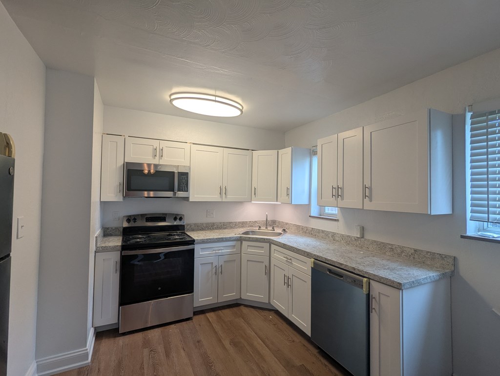 A kitchen with white cabinets and stainless steel appliances.