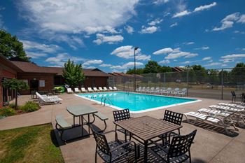 A pool with chairs around it at Deauville Park Apartments, Monroeville, PA