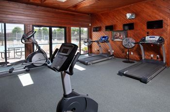A gym with treadmills, elliptical machines, and a stationary bike at Deauville Park Apartments, Monroeville, PA