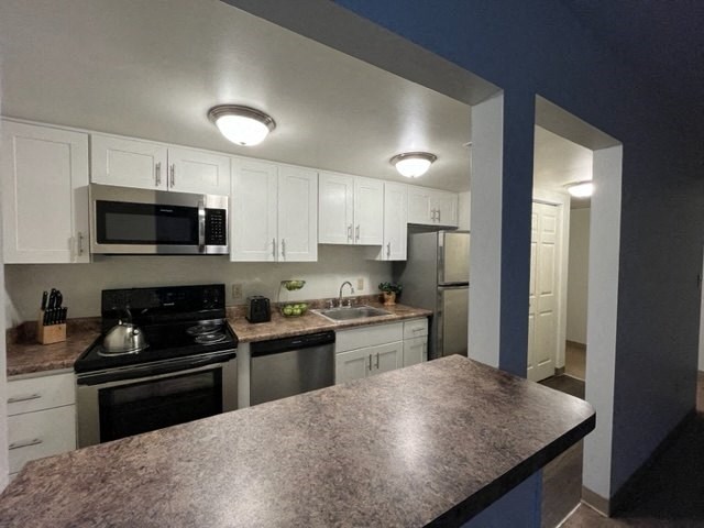 a kitchen with a stove a sink and a microwave at North Pointe Commons, Pittsburgh, PA