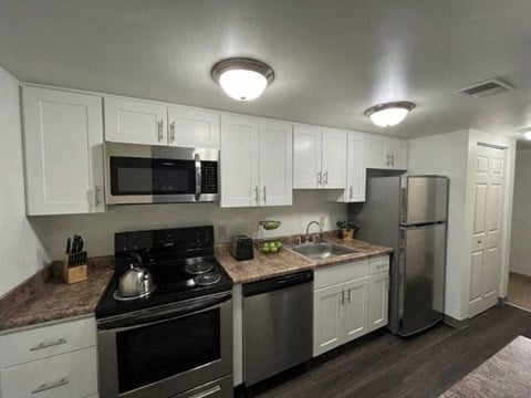 a kitchen with white cabinets and stainless steel appliances at North Pointe Commons, Pittsburgh
