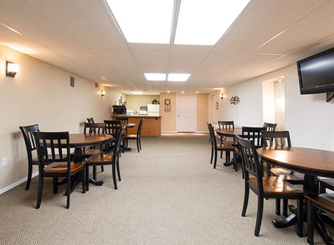 a dining room with tables and chairs and a kitchen