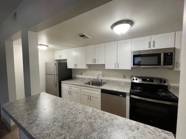 A kitchen with granite countertops and white cabinets.at North Pointe Commons Apts, Pittsburgh, PA