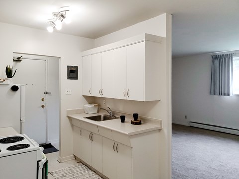 A white kitchen with a stove and cabinets.