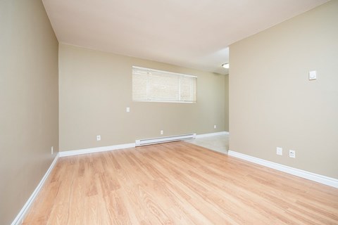 a living room with a hard wood floor and a window