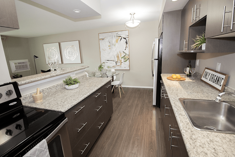 A kitchen with a black stove top oven and brown cabinets.