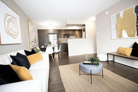 A modern living room with a white couch and a round table in the center.