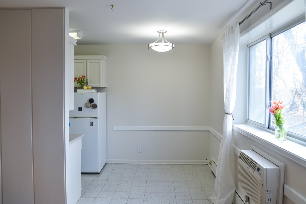 A kitchen with a white refrigerator and a white ceiling.