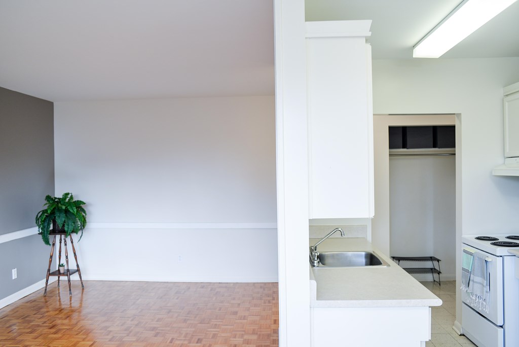 A kitchen with white cabinets and a white fridge.