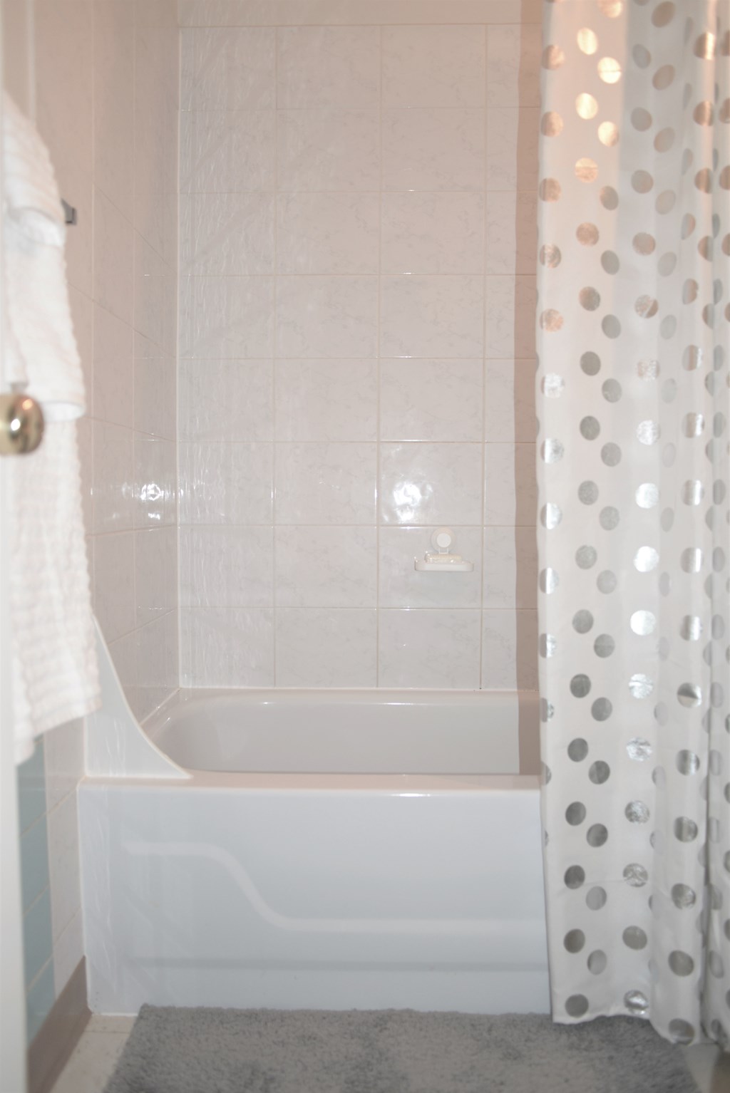 A white bathroom with a tub and a shower curtain.