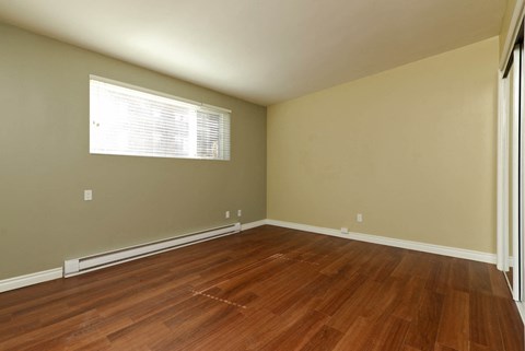 A room with wooden flooring and a window.