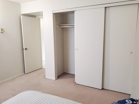 A bedroom with a bed, a wardrobe and a cupboard.