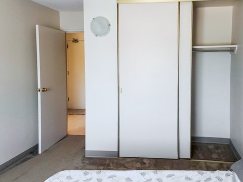 Large built-in closet with sliding doors in a bedroom at 1025 Munroe pet-friendly apartments in Winnipeg.