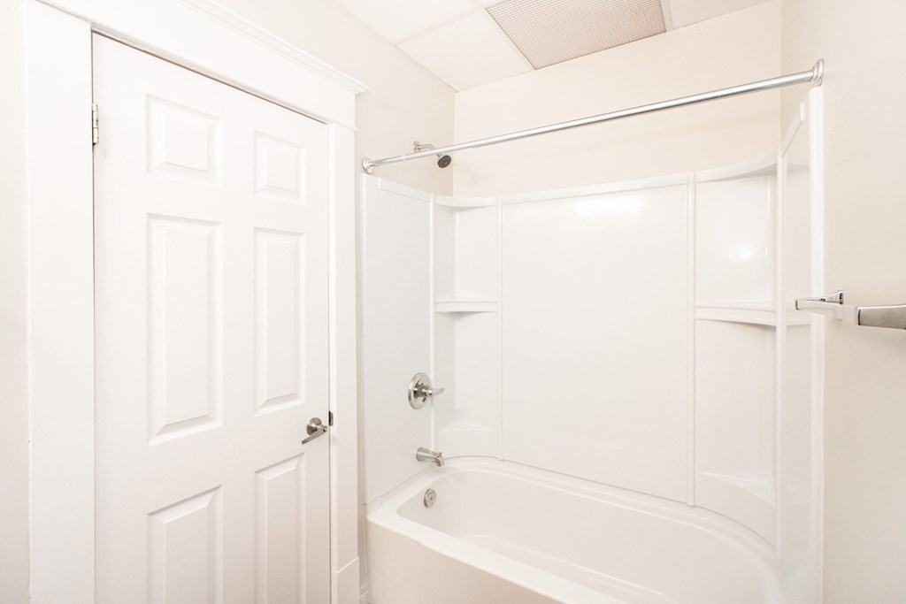 a white bathroom with a shower and a bath tub
