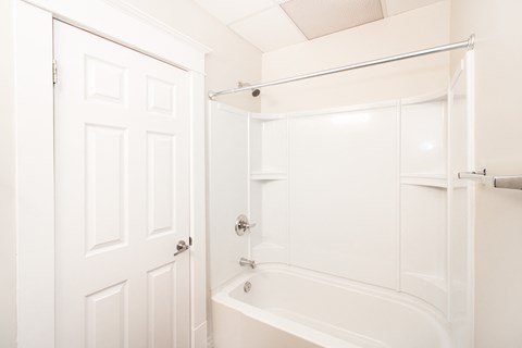 a white bathroom with a shower and a bath tub