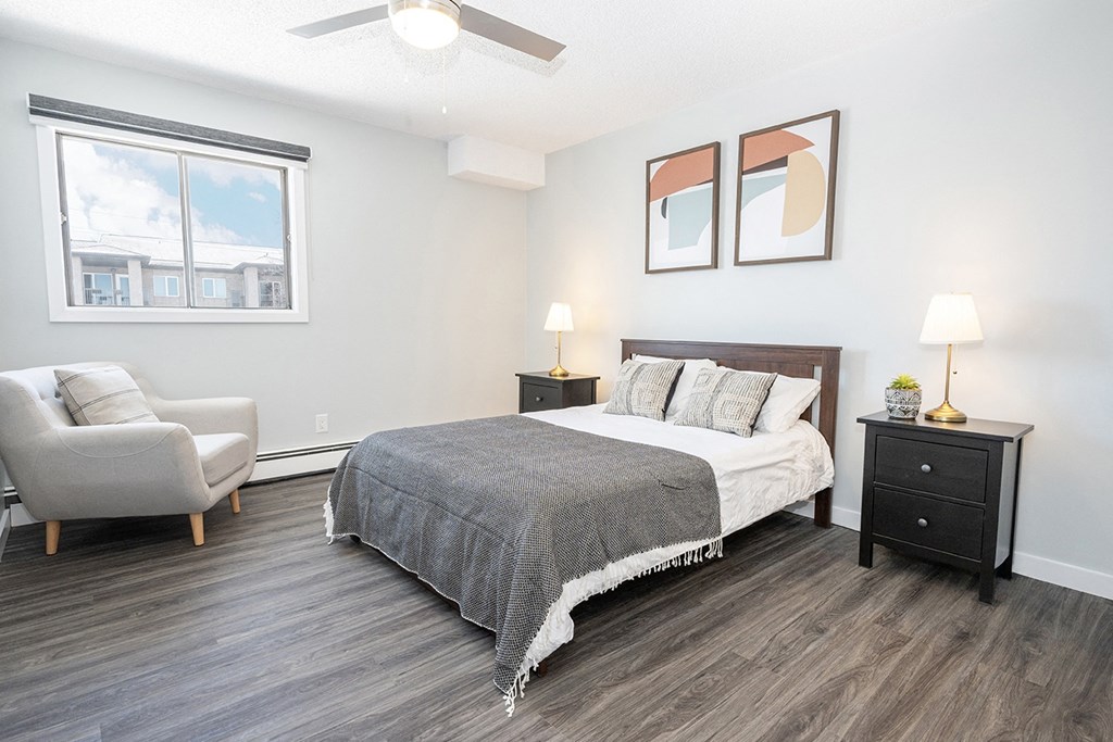 a bedroom with a bed and a chair and a window