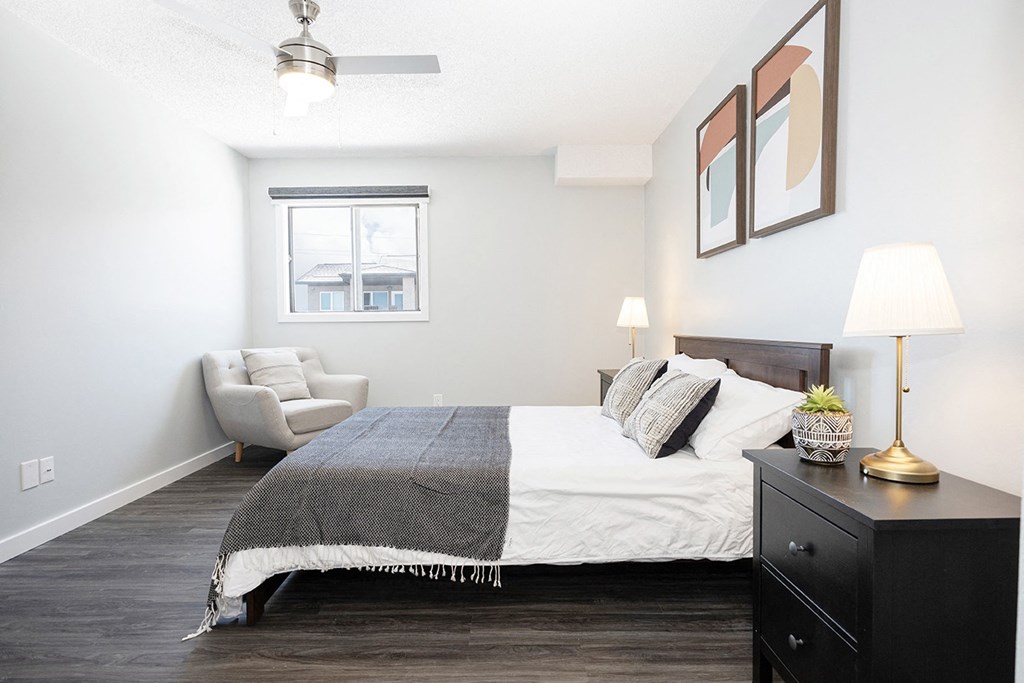 a bedroom with a bed and a chair and a window