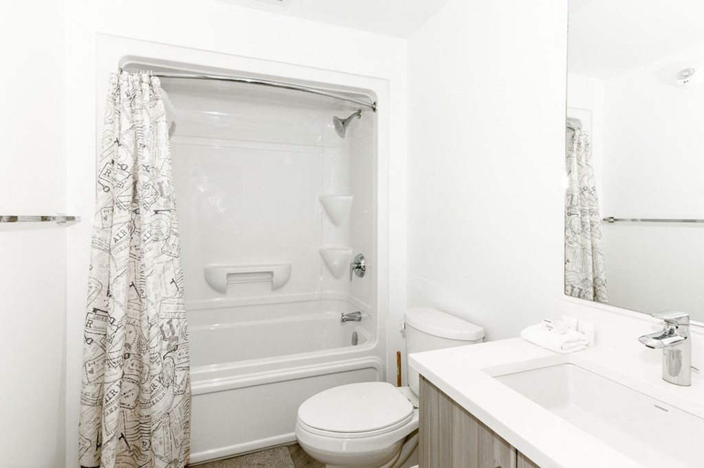 A white bathroom with a toilet, sink, and bathtub.