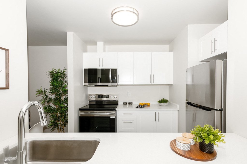 A modern kitchen with stainless steel appliances and white cabinetry.