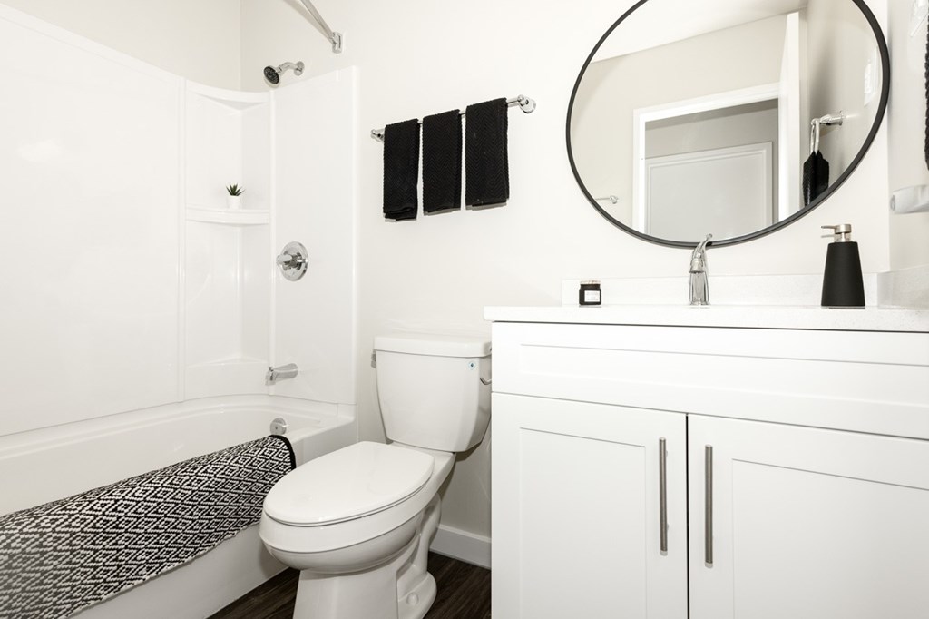 A white bathroom with a toilet, sink, and bathtub.