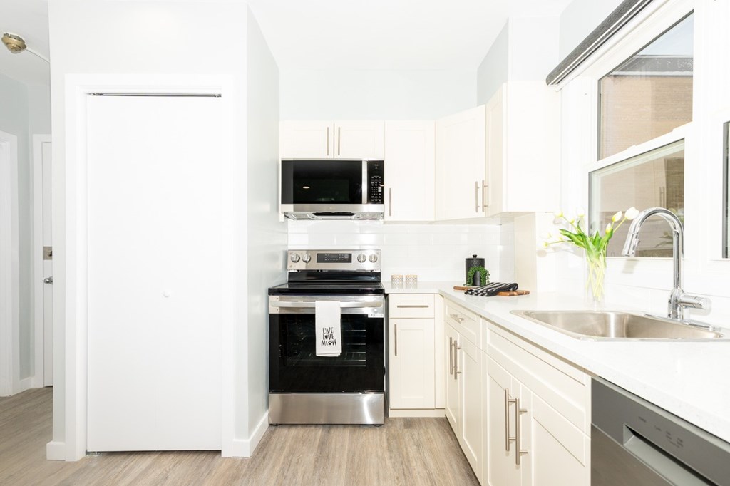 A modern kitchen with white appliances and wooden cabinets.